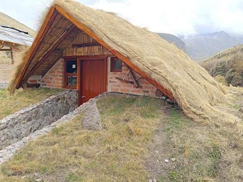 ChimborazoChimborazo Basecamp的山丘上一座带草屋顶的小建筑