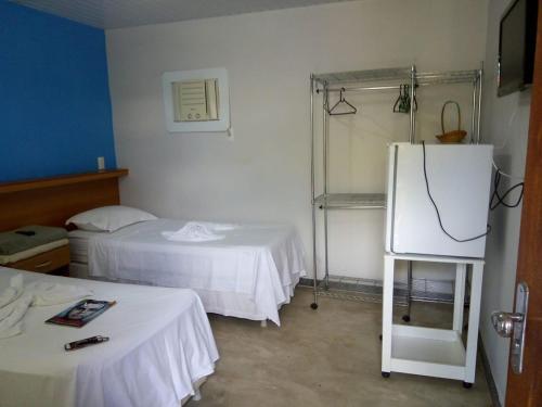 Santa CruzPousada In Paradiso的客房设有两张床和一台冰箱。