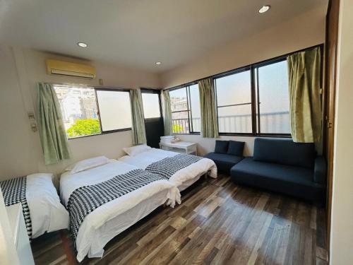 东京Ueno Iriya hostel的一间卧室配有一张床、一张沙发和窗户。