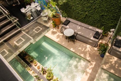 圣克鲁斯Cosmopolitano Hotel Boutique的享有带桌椅的游泳池的顶部景致