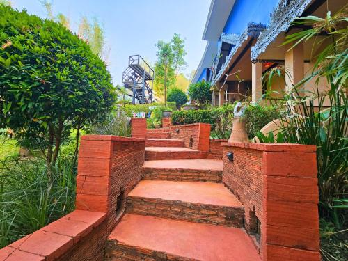 清迈Phu Jaya Floresta Resort by ALPHATEL的建筑物前面的一套砖台阶
