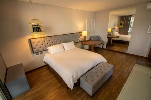 圣克鲁斯Cosmopolitano Hotel Boutique的卧室配有一张白色的大床和一张沙发。