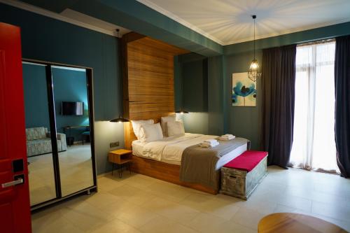 巴统Boulevardside的一间设有床铺的卧室,位于一个拥有绿色墙壁的房间