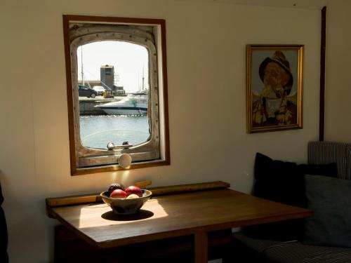 海斯勒Unique Boat Accomodation - Bornholm - Fjælstavn的镜子前木桌上放一碗苹果