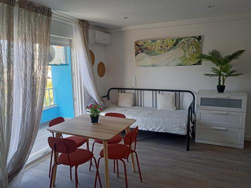 卡帕里卡海岸Mata Beach Caparica的卧室配有一张床和一张桌子及椅子