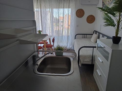 卡帕里卡海岸Mata Beach Caparica的带水槽的厨房和1间带1张床的卧室