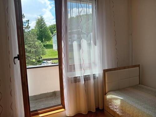 普利特维采湖Apartman "Plitvice and You"的卧室设有窗户,窗户旁边设有一张床
