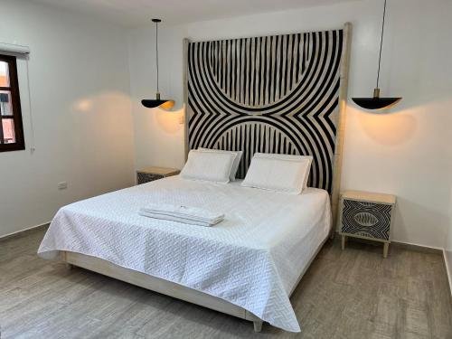 巴耶杜帕尔Hotel Valledupar Plaza的卧室配有白色的床和2条毛巾
