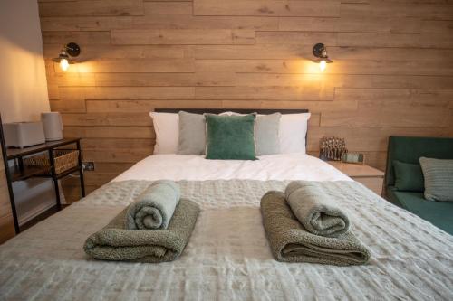 伊斯特布恩Emerald nest Eastbourne的一间卧室配有一张大床和毛巾