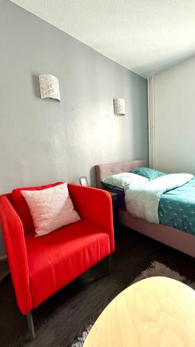 圣但尼Chambre Privée Kozy - Stade de France的一间卧室配有红色椅子和一张床