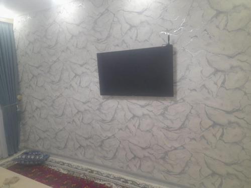 希瓦Ancient Khiva Apartment 3的石墙上的平面电视