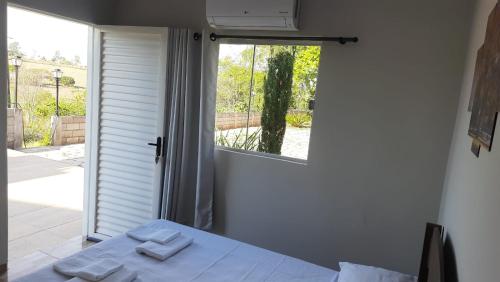 圣若昂-达巴拉Pousada Chacara Princesa Isabel的客房设有床和带毛巾的窗户。