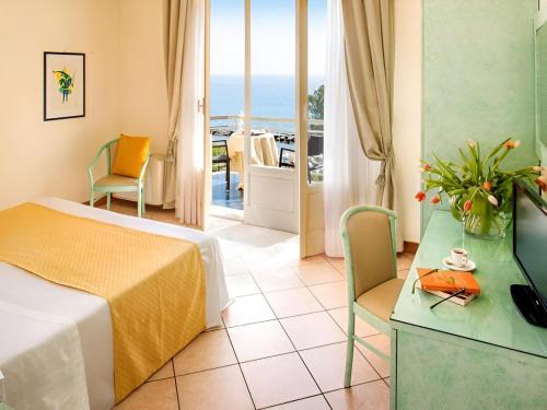 迪亚诺马里纳Hotel Eden Park的酒店客房设有一张床,享有海景。