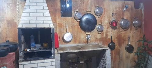 新弗里堡Casa girassol的厨房配有挂在墙上的锅碗瓢盆