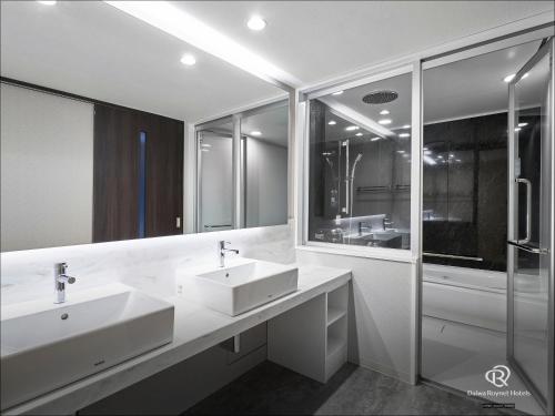 青森Daiwa Roynet Hotel Aomori的一间带两个盥洗盆和淋浴的浴室