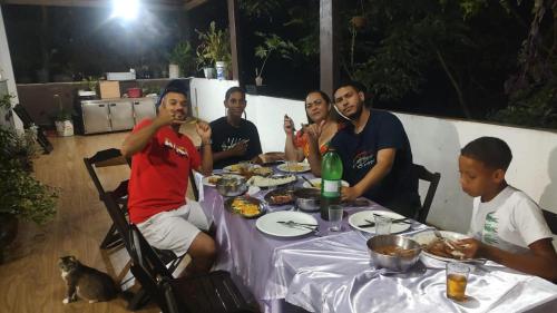 里约热内卢Repouso do corcovado hostel的一群坐在桌子旁吃食物的人