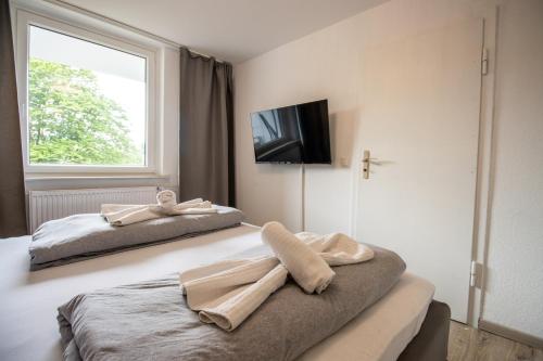 汉诺威Messe-Apartment für 5 Gäste mit Balkon und Lift的一间卧室配有两张带毛巾的床
