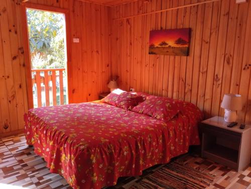 黑岛"PINARES DEL MAR" Pequeñas cabañas ECO rusticas sello "S"的一间卧室配有一张带红色毯子的床