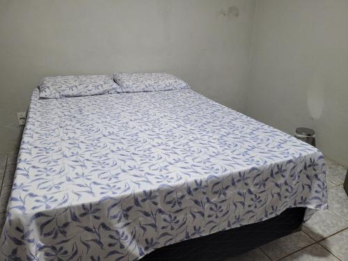 北茹阿泽鲁Quarto - Canto Juazeirense的一张带蓝色和白色棉被的床