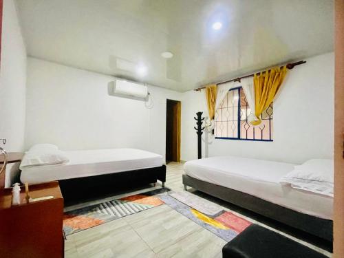 圣何塞德尔瓜维亚雷Alojamiento campestre San Miguel的一间卧室设有两张床和窗户。