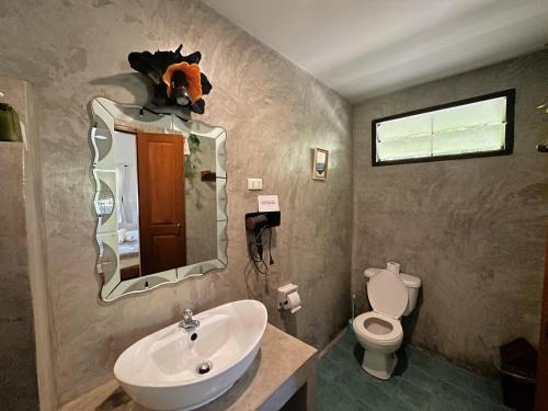 拜县Pairadise Hotel的一间带水槽、卫生间和镜子的浴室