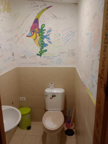 普拉亚布兰卡Taca Tucan Hostel的一间带卫生间的浴室和一面墙上写着的墙壁