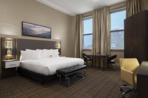 达文波特爱荷华州柯伦特傲途格精选酒店的配有一张床和一张书桌的酒店客房