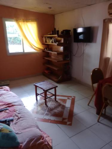 普拉亚布兰卡Taca Tucan Hostel的客厅配有桌子和电视