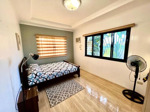 大雅台Sierra Pines Place Tagaytay的一间卧室设有一张床和一个窗口