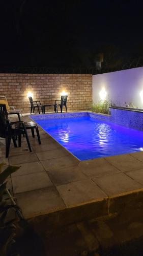 特尔马斯德里奥翁多Habitacion con baño的夜间游泳池,拥有蓝色照明