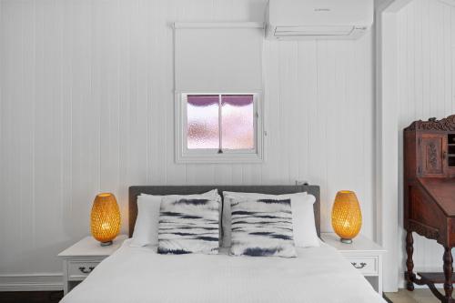 Bli Bli"Xanadu" Charming 2-Bed Retreat by Marcoola Beach的一间卧室配有一张带两盏灯的床和一扇窗户。