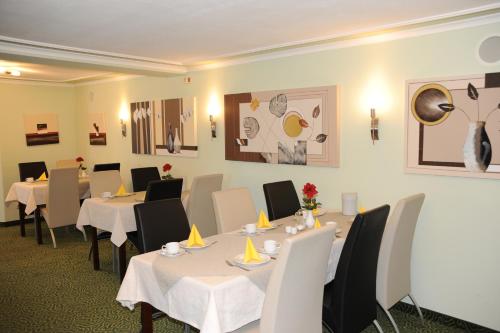 沙伊代格波斯特酒店的用餐室配有白色的桌子和白色的椅子