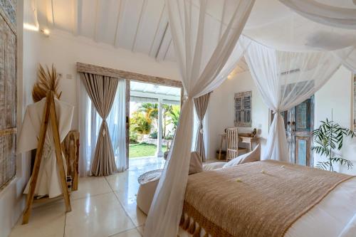 珀尼达岛Atalaya Villas Nusa Penida的一间卧室配有一张带天蓬的床