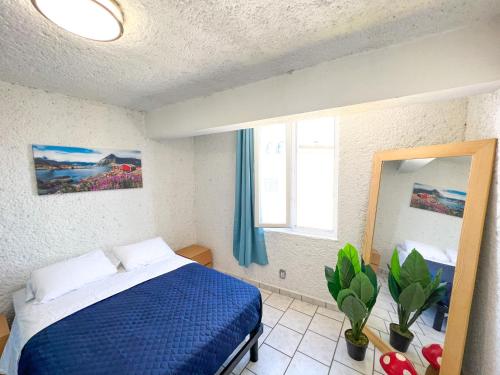 克雷塔罗克雷塔罗RJ酒店的一间卧室配有蓝色的床和镜子