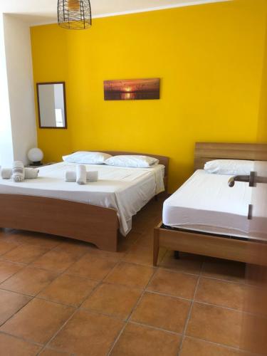 切萨雷奥港Oasi的黄色墙壁的客房内的两张床