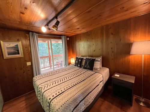 帕克伍德The Cabin in Packwood的木制客房内的一间卧室,配有一张床