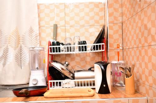 KisiiNyamira homes的厨房柜台配有带餐具架的餐具