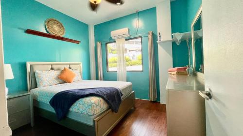 NgermidNgermid Oasis - Vibrant 2 BD/1 BA Duplex的蓝色的卧室设有床和窗户
