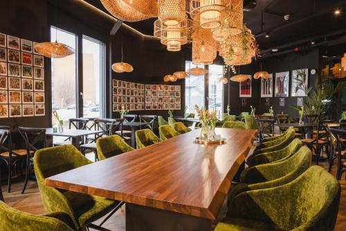 斯图加特Rioca Stuttgart Posto 6的一间带木桌和绿色椅子的用餐室