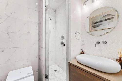 纽约Luxurious 3 Bedroom Beautifully Renovated Loft的带淋浴、水槽和镜子的浴室