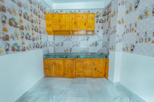 马拉里Luvya Retreats Hotel的厨房配有木制橱柜和瓷砖墙。