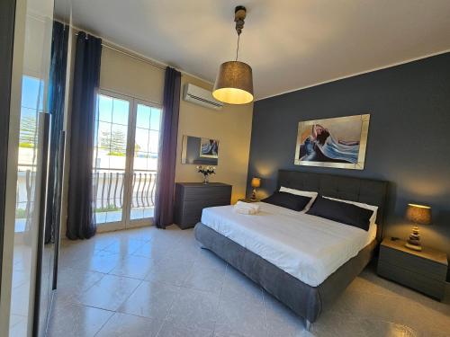 冯塔尼比安奇Appartamenti - Villa Merilusi的一间卧室设有一张床和一个大窗户