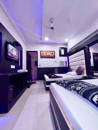 新德里PEACE POINT FAMILY HOTEL By AKJ的酒店客房设有两张床和电视。