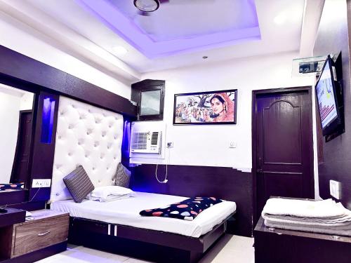 新德里PEACE POINT FAMILY HOTEL By AKJ的一间带两张床的卧室和一台电视