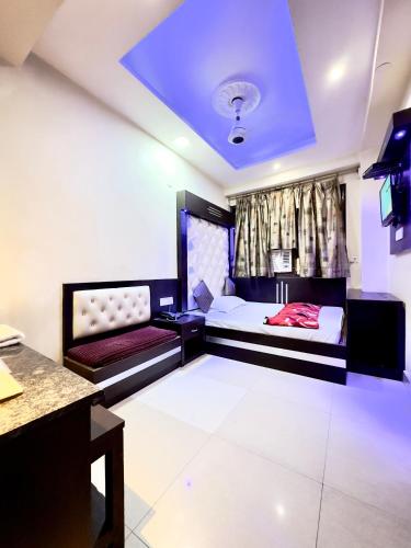 新德里PEACE POINT FAMILY HOTEL By AKJ的客房设有两张床、一张桌子和一台电视机。