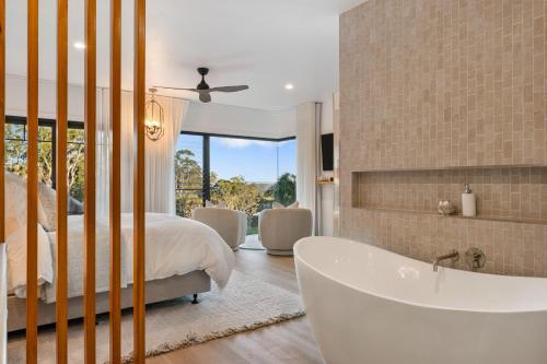 土乌巴Ridge Retreat的主卧室设有浴缸、床和窗户