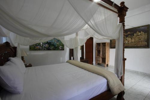 乌布Belvilla 93916 Budi House Near Ubud Palace的一间卧室配有一张带天蓬的白色床