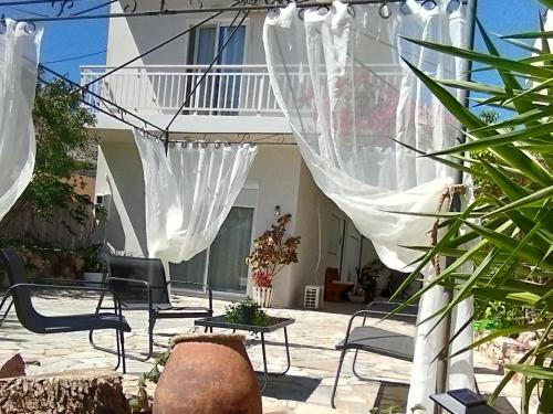里瓦的亚Marilen的房屋前设有带椅子和窗帘的天井