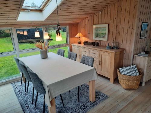 伦斯楚普Cozy Summer House In Lnstrup For 5 People,的一间配备有白色桌椅的用餐室