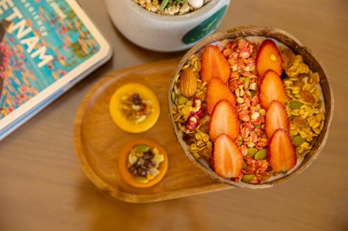富国SOLÉA Hotel GrandWorld Phu Quoc的木板上的一碗食物,水果